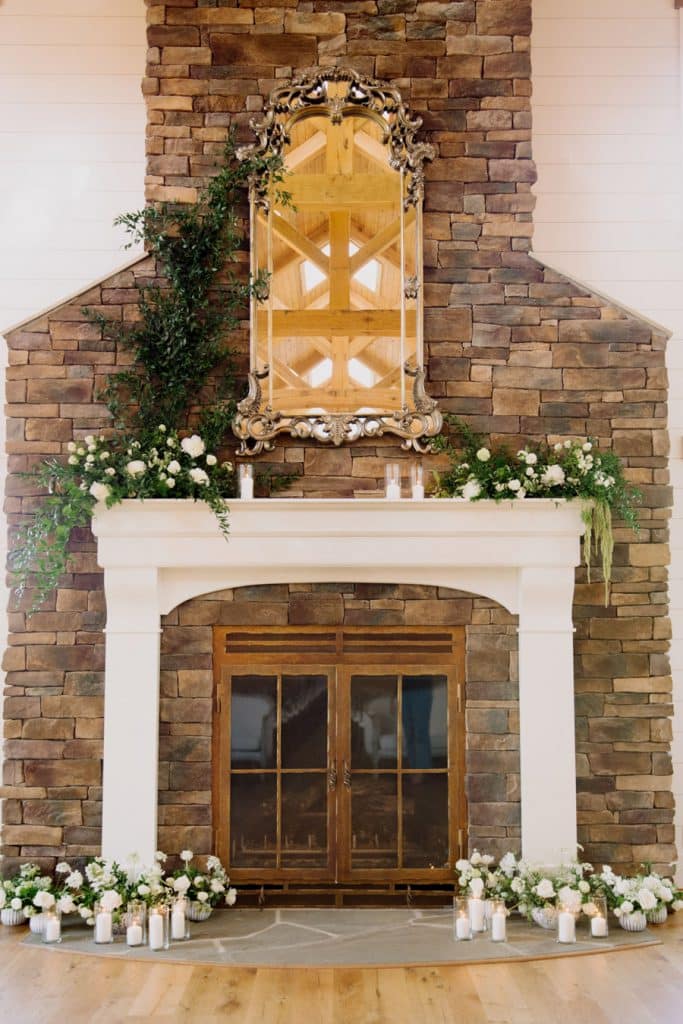 Stone Fireplace Decorated with White Flowers & Greenery