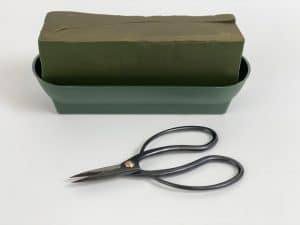 floral foam in a green container with scissors