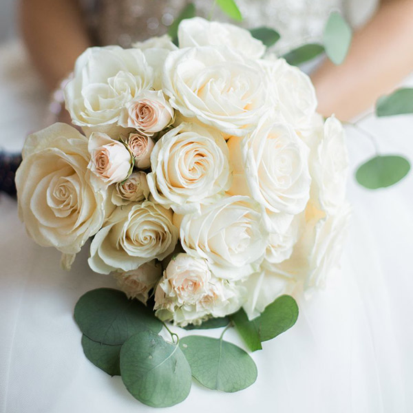 A simple bouquet of roses and spray roses with some eucalyptus.