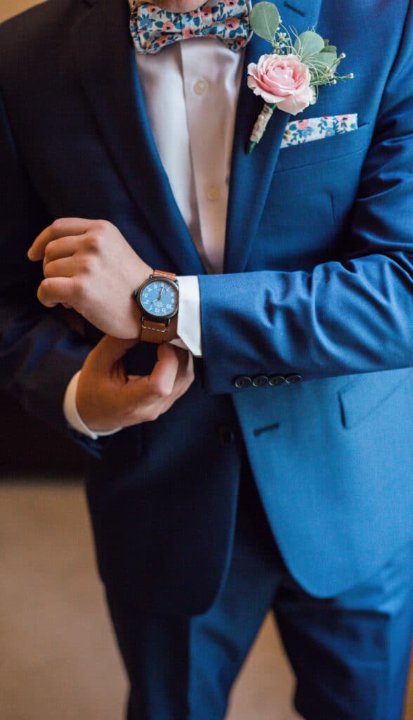 Pink roses, wax flowers, and silver dollar eucalyptus make up the boutonniere