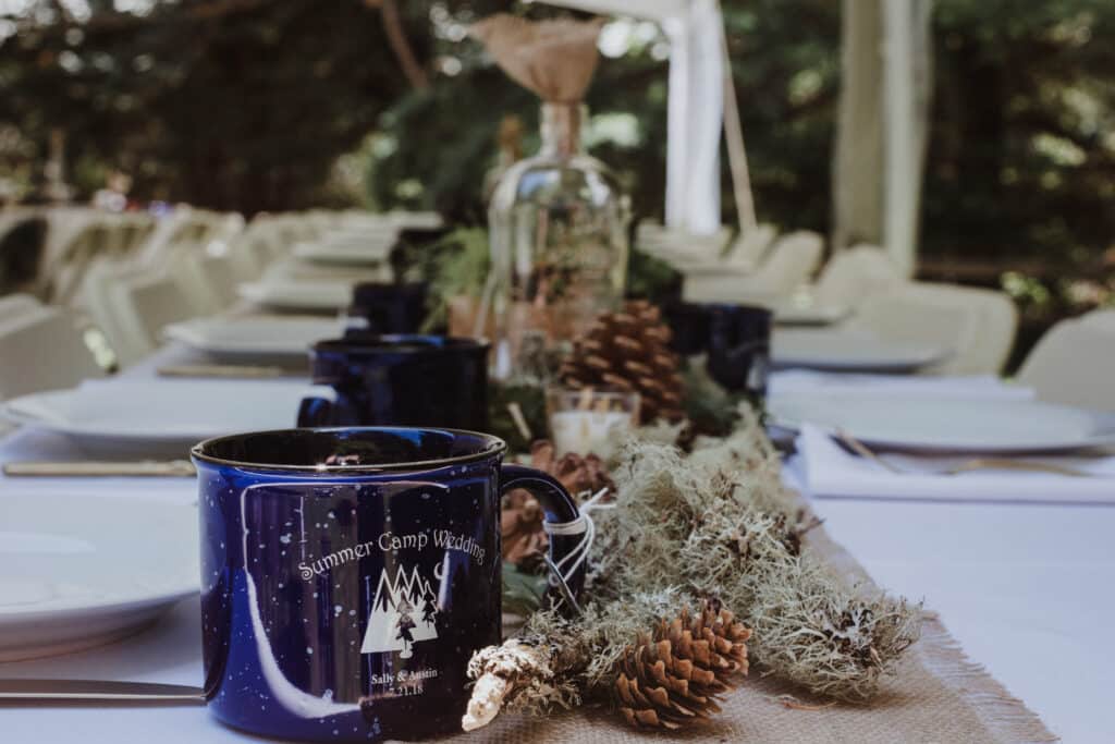Table lineed with pincones and greenery Bohmian camp wedding theme