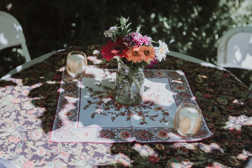 Mason Jars filled with mums for camp Bohemian wedding