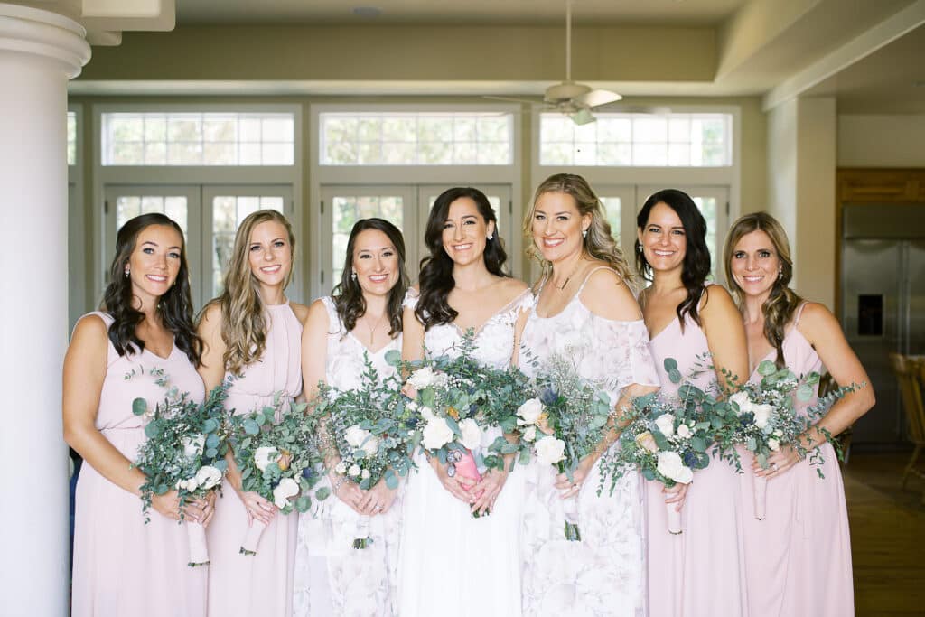 bridal party holding white and green bridal bouquets