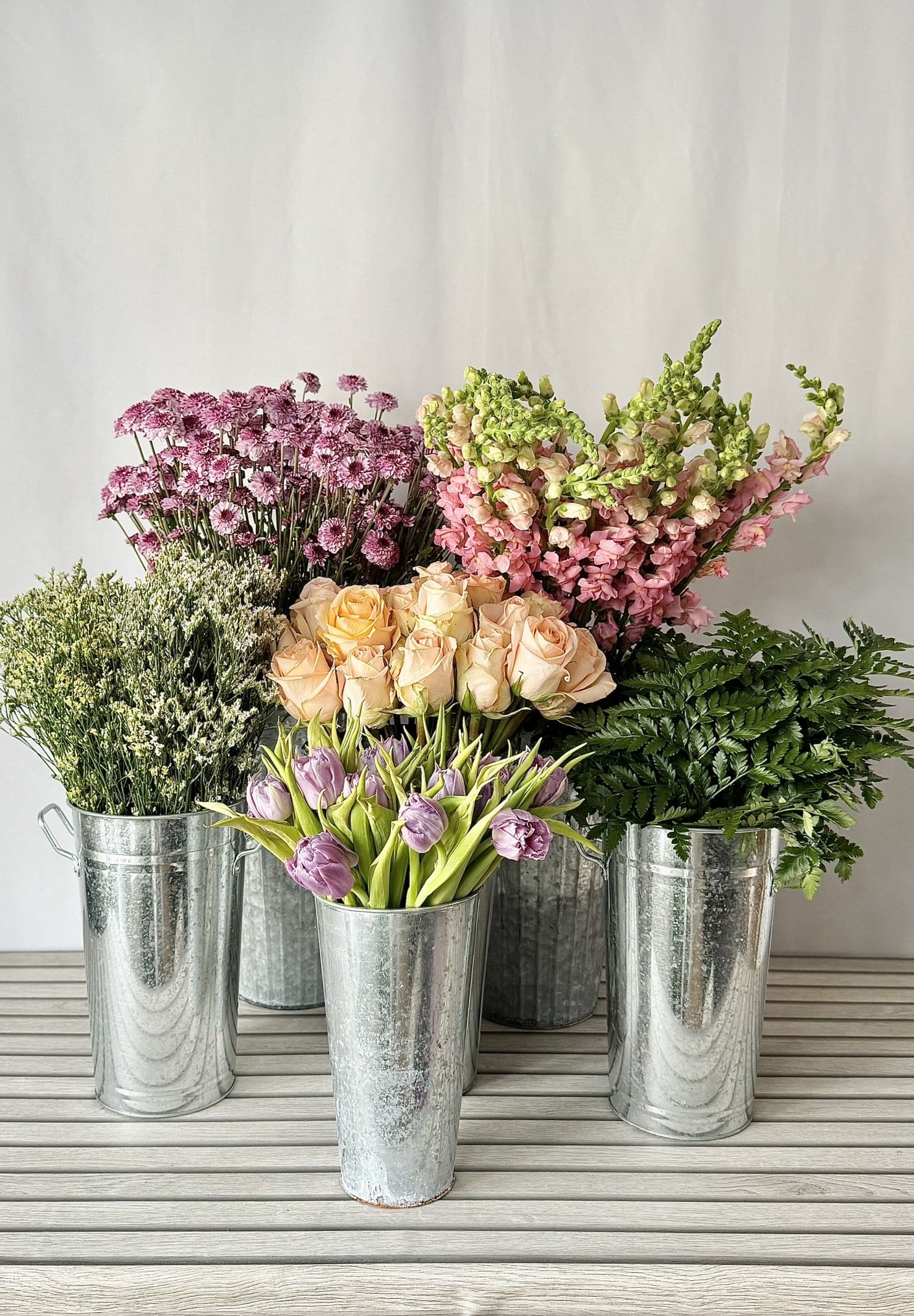 A bouquet bar setup in silver galvanized buckets.