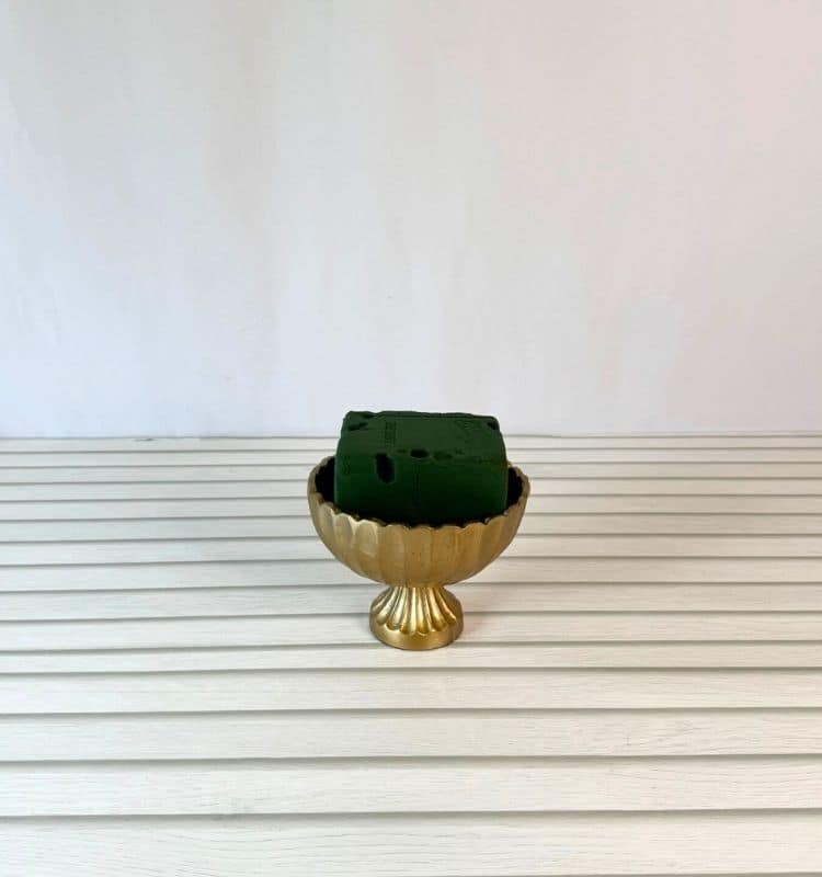 a gold vessel with floral foam