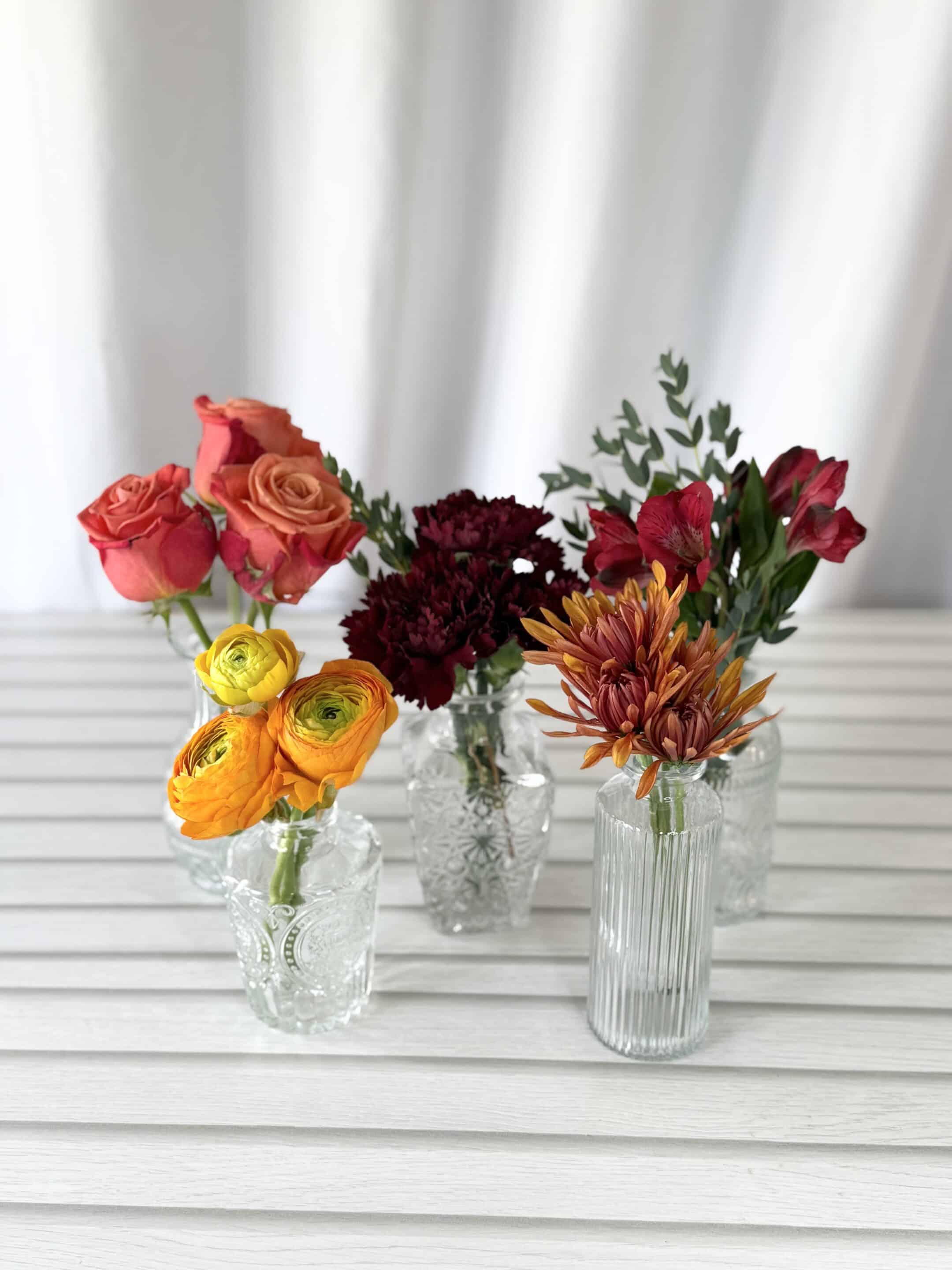 Flowers in fall shades in bud vases