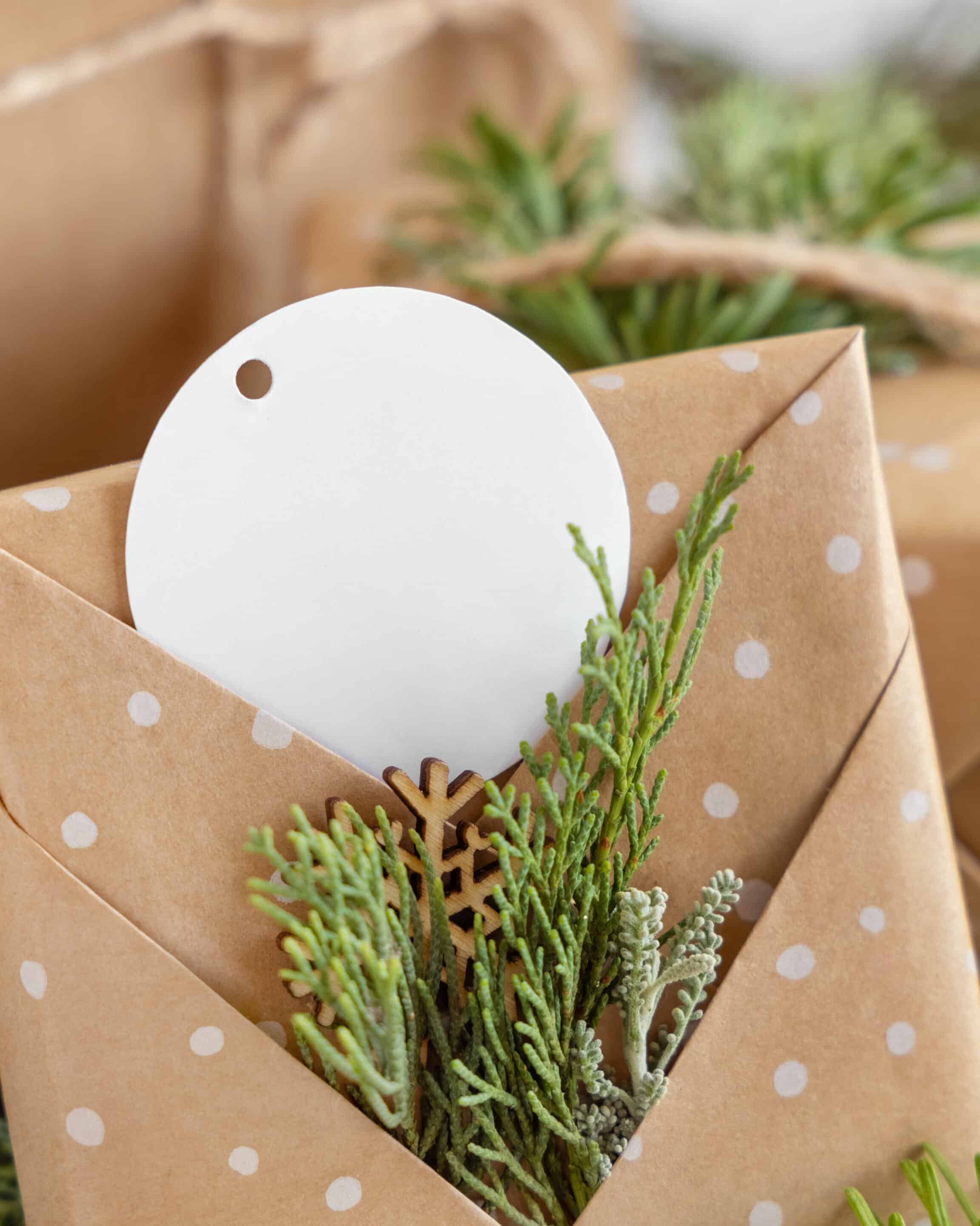 a Christmas present wrapped with fresh holiday greenery decor.