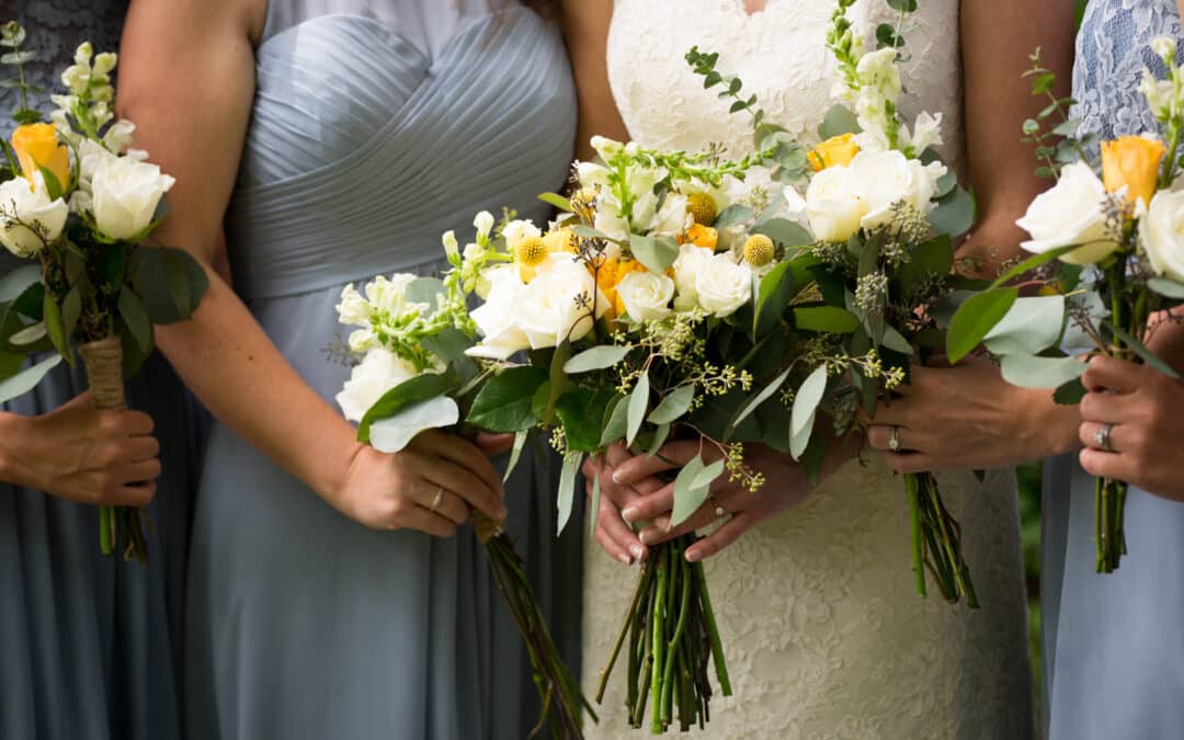 bride and bridesmaids holding flower bouquets.