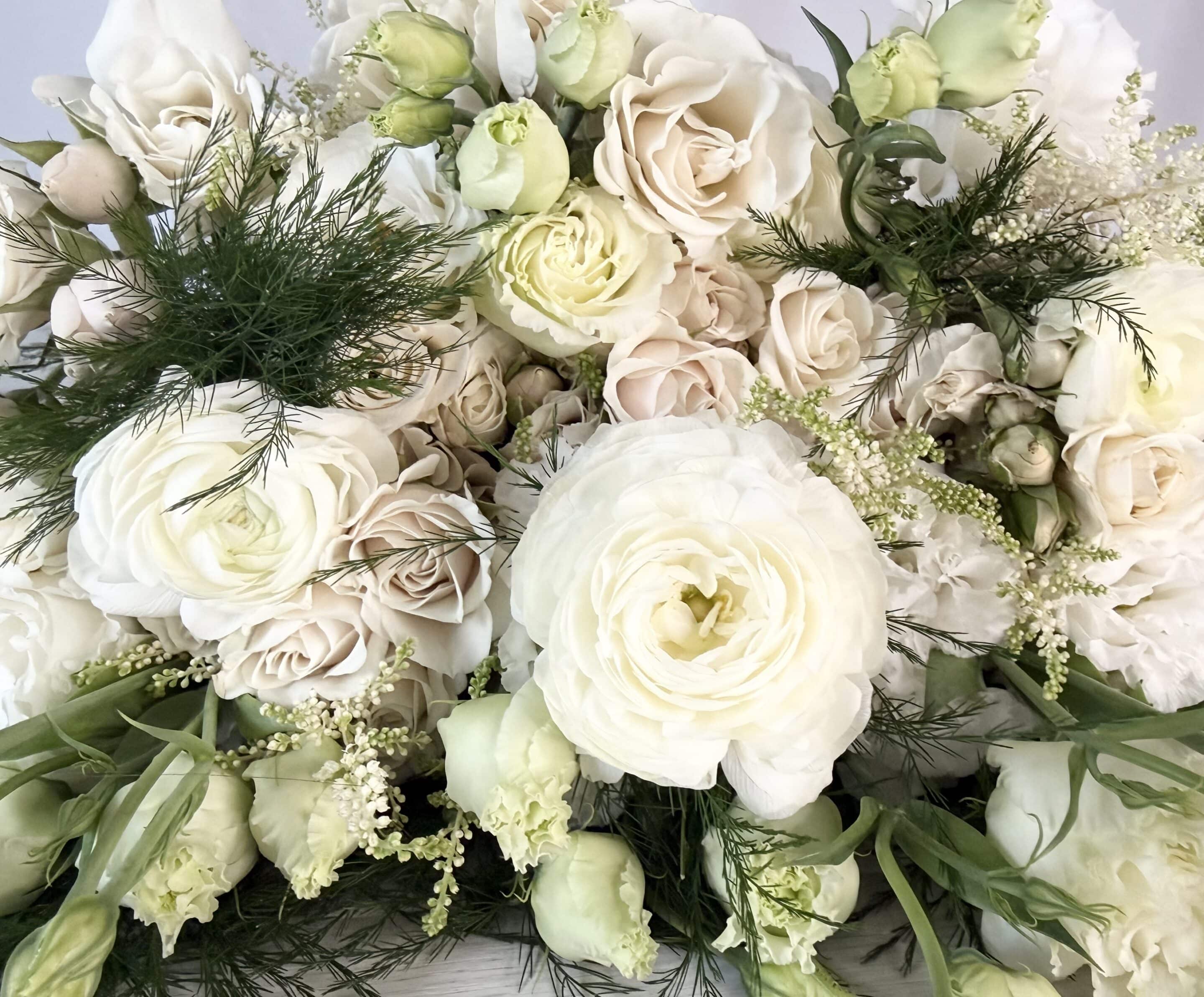 a closeup of our cloud dancer flower pack. It features lisianthus, spray roses, ranunculus, astilbe, and tree fern.